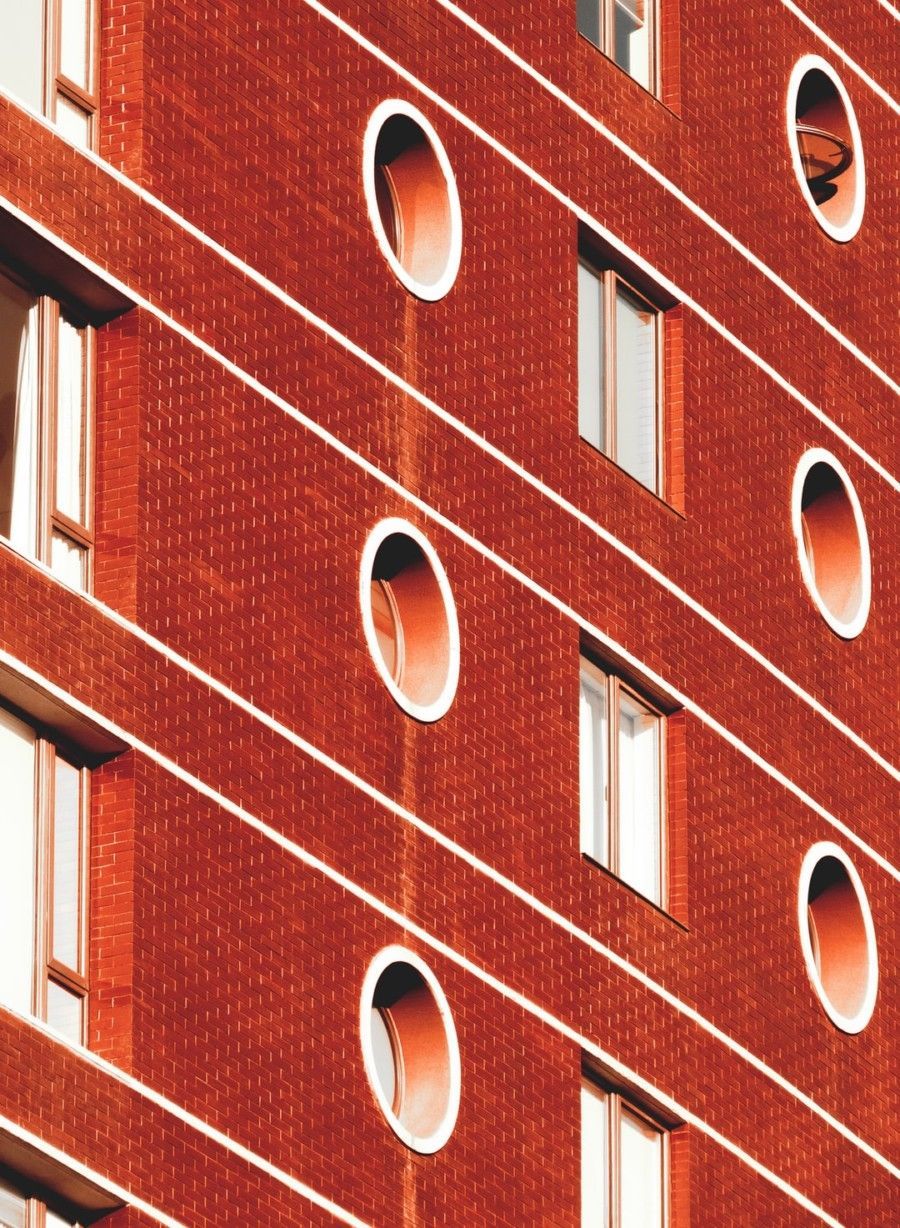 red-concrete-building-with-round-and-square-windows