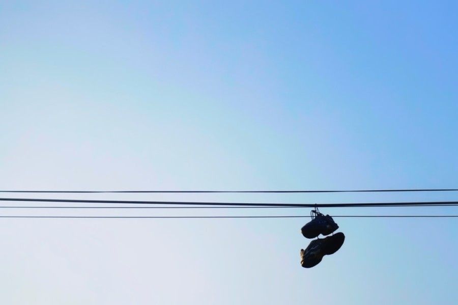 silhouette-of-pair-of-shoes-hanging-on-wire