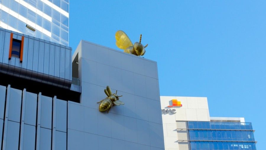 two-gold-bee-statues-on-building
