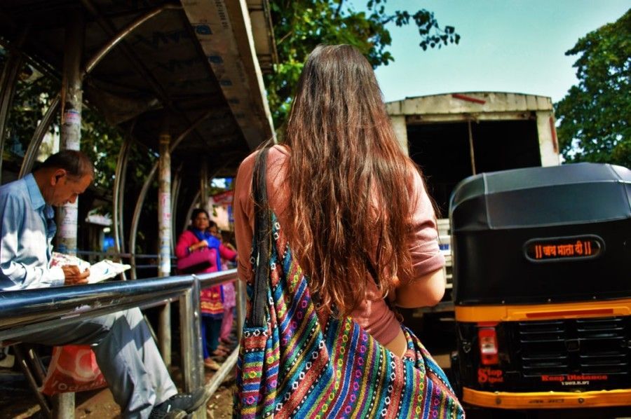 woman-walking-beside-autorickshaw-during-daytime