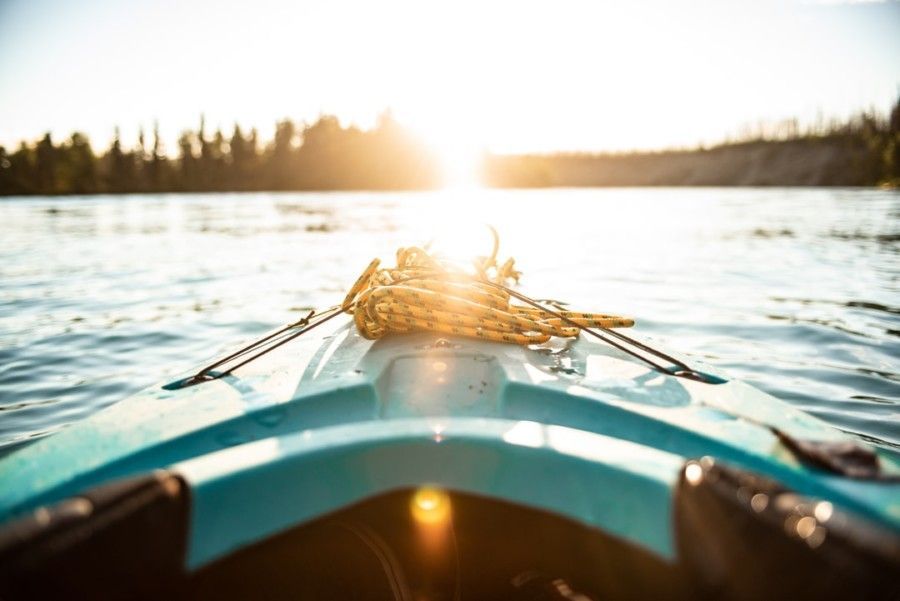 blue-kayak-on-body-of-water-during-golden-hour