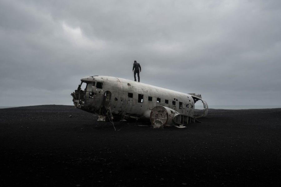 person-standing-on-wrecked-airplane-under-gloomy-sky