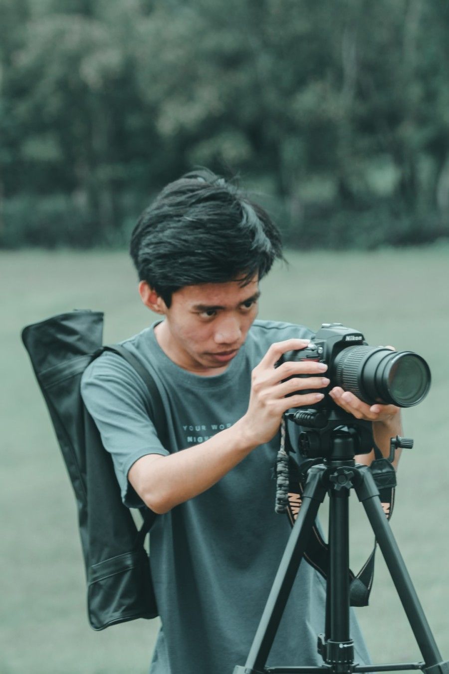 man-using-camera-on-tripod-stand-during-daytime
