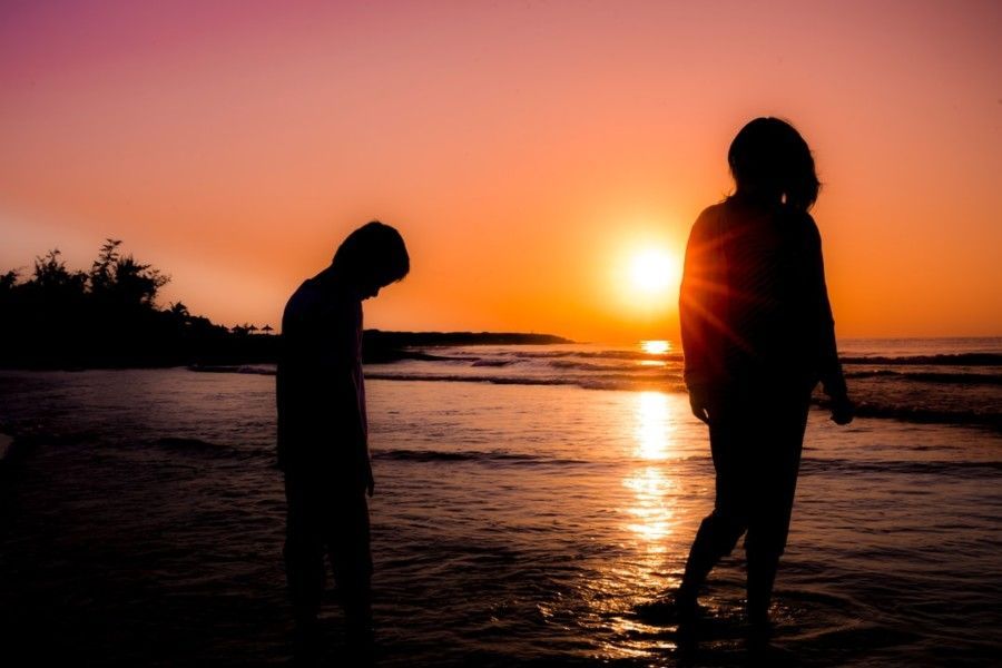 silhouette-photography-of-boy-and-girl-standing-at-beach
