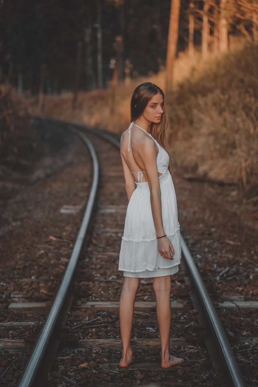 woman-standing-on-train-rail-near-outdoor-during-daytime